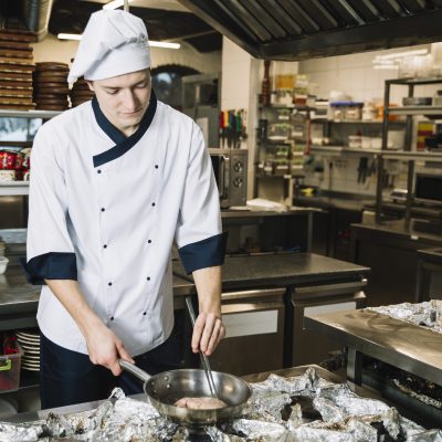 male-cook-frying-meat-pan-stove